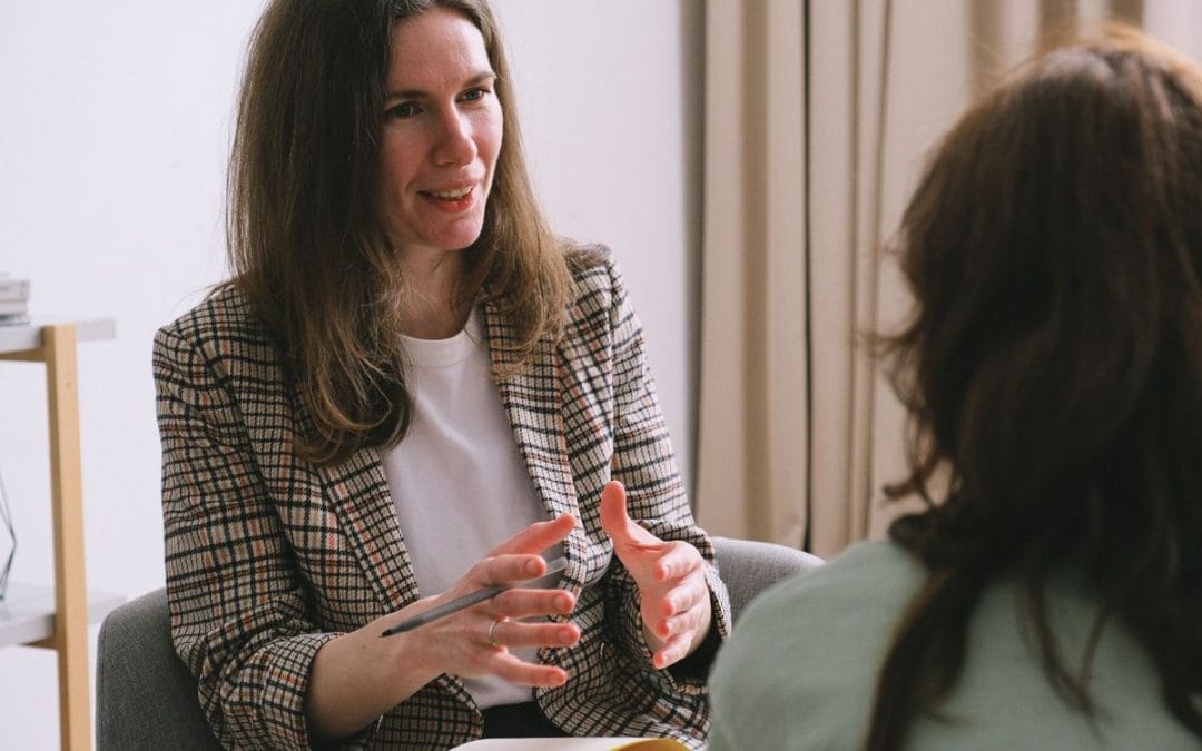 Counsellor talking with a client in a softly lit room